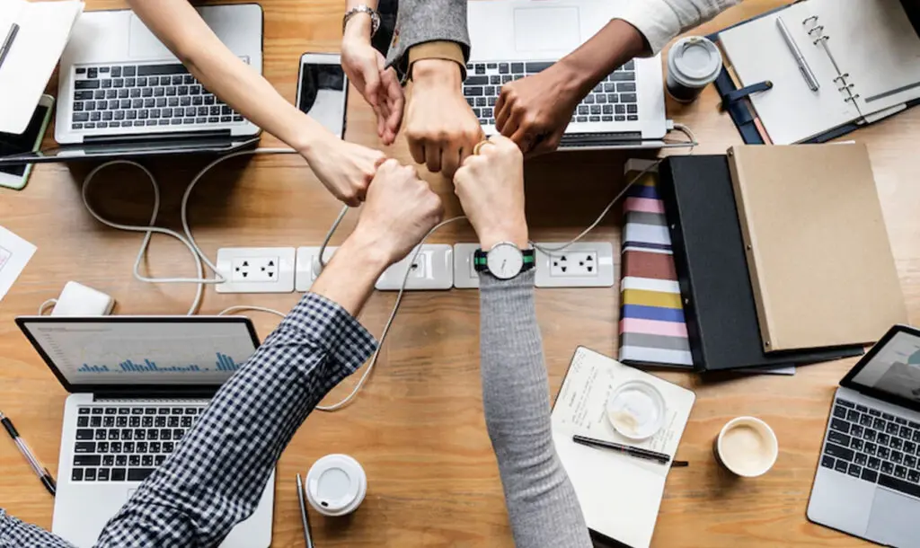 Equipo de trabajo chocando los puños